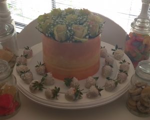 Bridal shower cake with fresh roses and chocolate coated strawberries