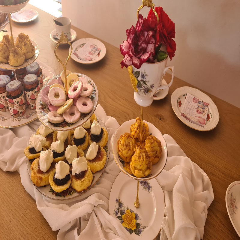 Sugar cookies and assorted scones with jams and whipped cream